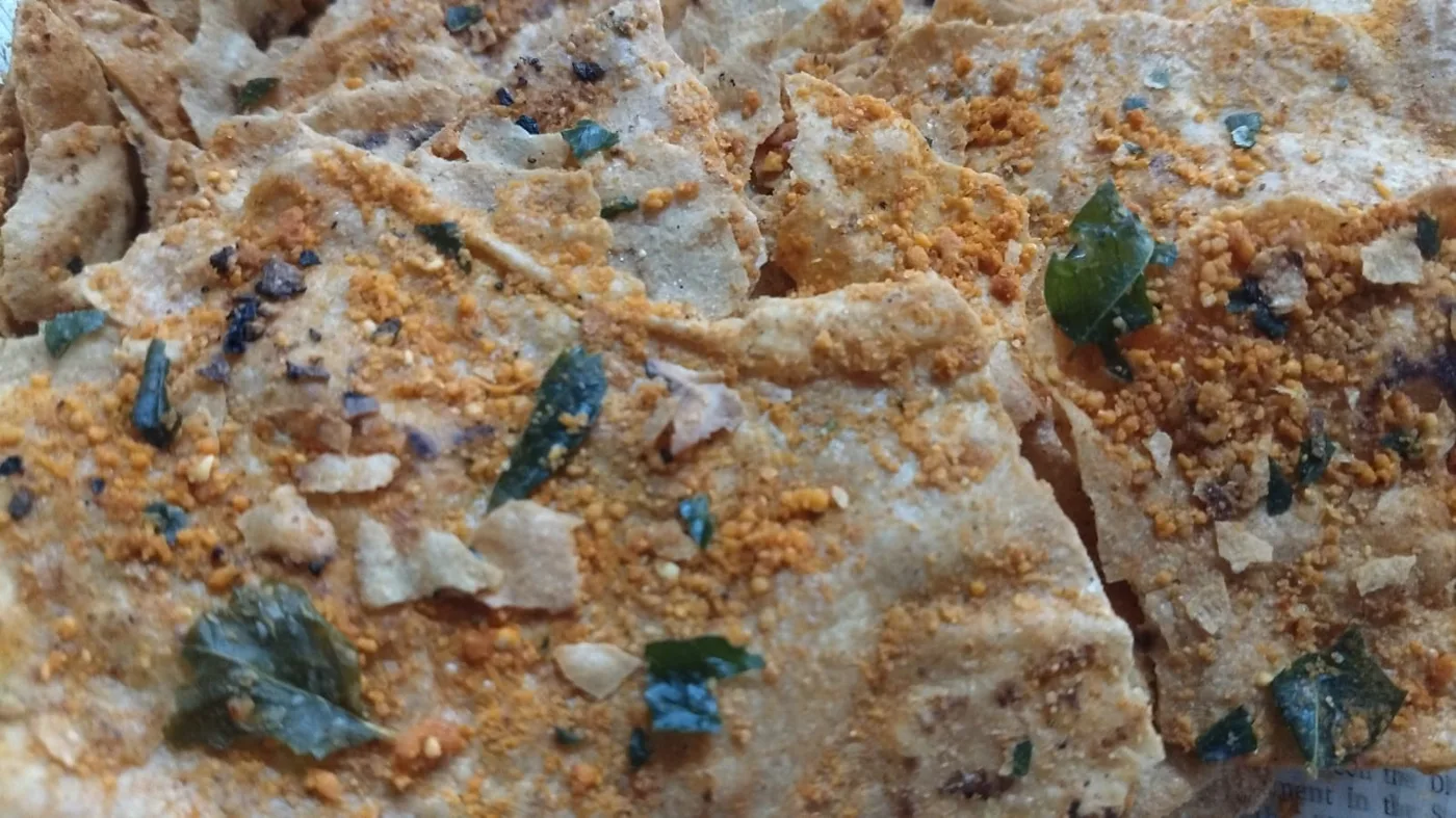 Crisp jowar masala roti shards with curry leaves and spice.