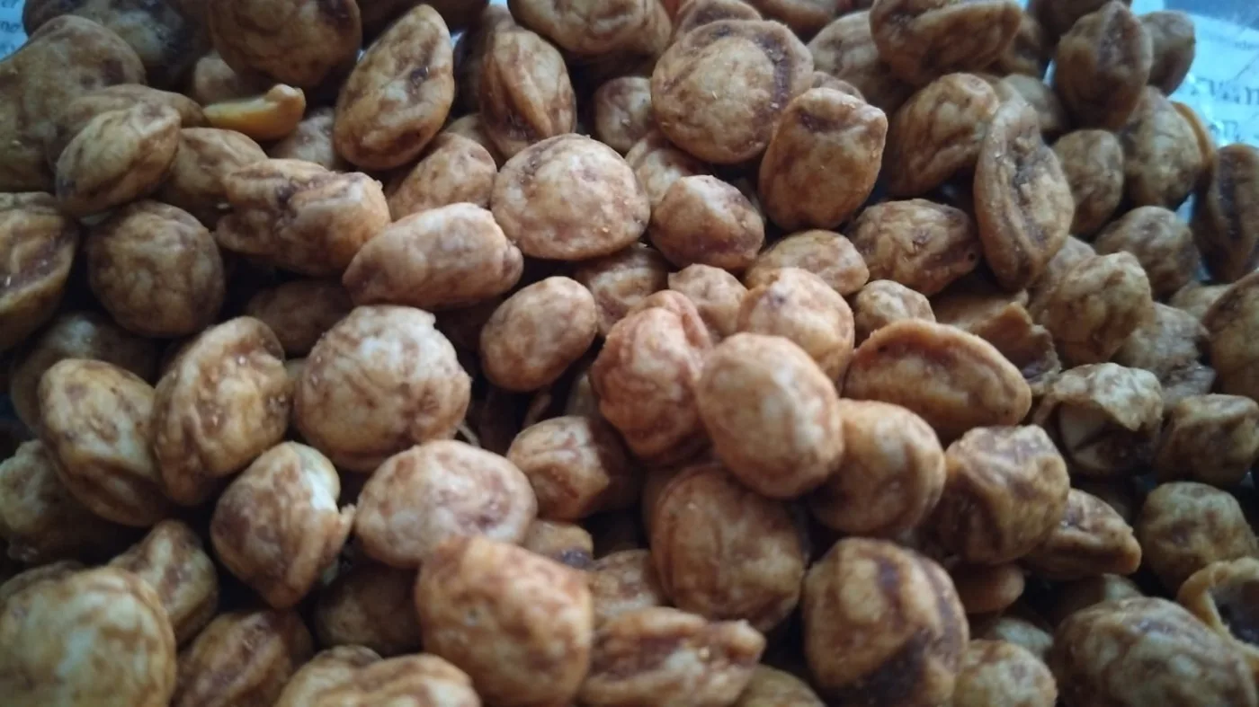 Roasted coated shell peanuts piled together.